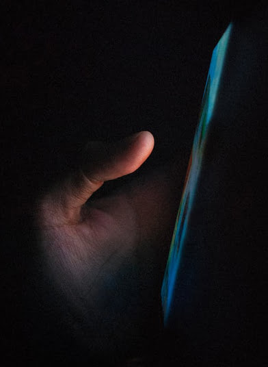 Telephone person holding blue light in dark room